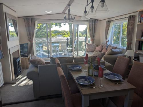 米尔福德昂西STUNNING LUXURY Caravan on edge of New Forest on SHOREFIELD Country Park ENTERTAINMENT AND LEISURE PASSES INCLUDED的客厅配有桌子和沙发