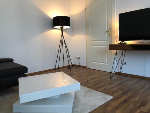 美因茨APT im Herzen von Mainz的客厅配有电视、沙发和桌子
