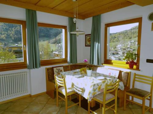 莫埃纳Ciasa Gran Panorama Moena的一间带桌椅和窗户的用餐室