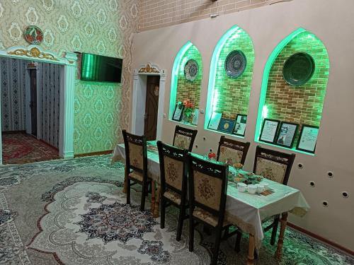 希瓦Khiva Ibrohim Guest House的一间带桌椅和窗户的用餐室