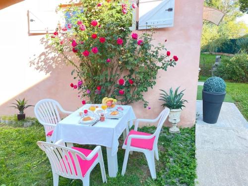 圣普列斯特Casa Luciana的花园内一张带粉红色椅子的白色桌子