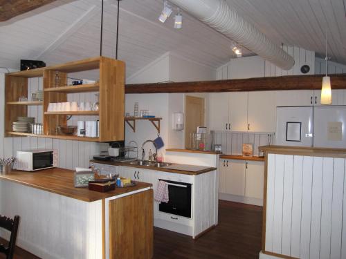 耶夫勒Hotell Ramudden的一间铺有木地板的大厨房,拥有白色的墙壁和木地板。