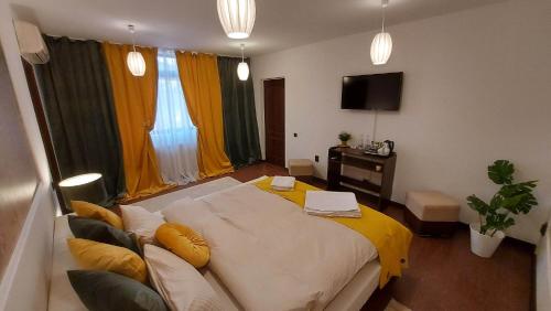 布加勒斯特Ambiennt的一间卧室配有一张带黄色毯子的大床