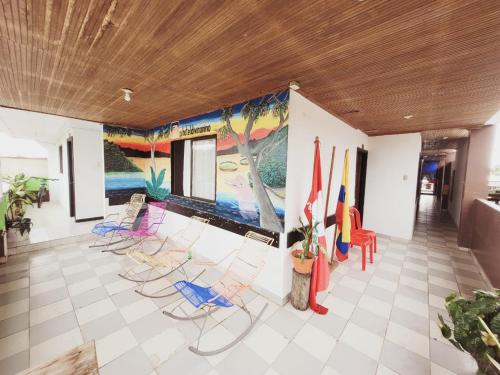 莱蒂西亚Divino Niño Hotel的一间设有椅子的房间和墙上的绘画