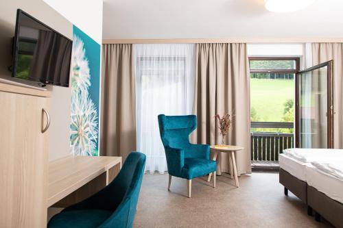 KleinzellGesundheits- & Wellnessresort Salzerbad的酒店客房,配有一张床、一张桌子和椅子