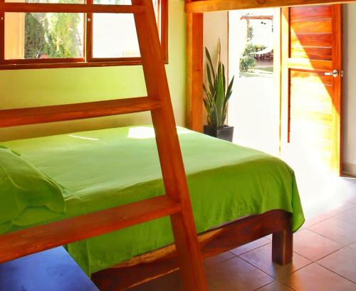 锡瓦塔塔内霍BM Zihua Casa de Huéspedes的一间卧室配有一张双层床和绿色的床罩