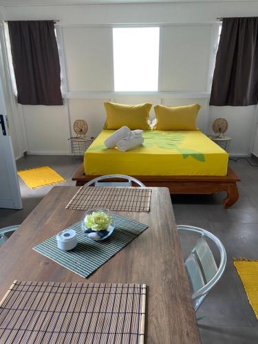 帕皮提Bungalow APETAHI的客厅配有黄色的床和桌子