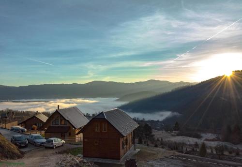 ZaovineTarovuk cabin的太阳从山上升起的村庄的景色