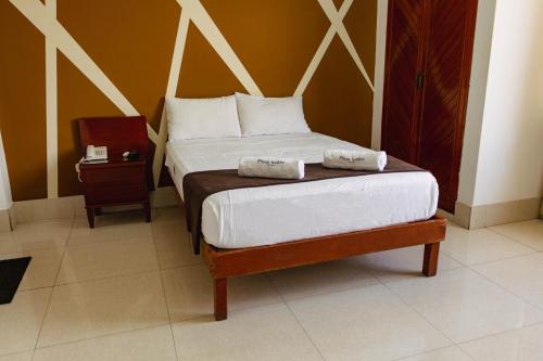 齐克拉约Hotel Plaza Teatro的一间卧室配有一张床,上面有两条毛巾