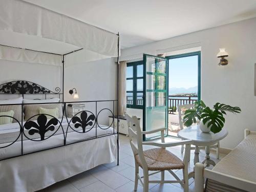 赫索尼索斯Creta Maris Resort的一间卧室配有一张床铺和一张桌子,还有一间用餐室