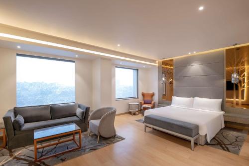 加济阿巴德Radisson Blu Towers Kaushambi Delhi NCR的酒店客房,配有床和沙发