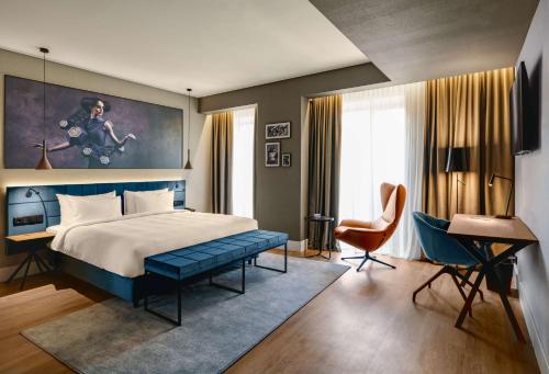 布拉索夫Radisson Blu Aurum Hotel, Brasov的一间卧室配有一张床、一张桌子和一把椅子