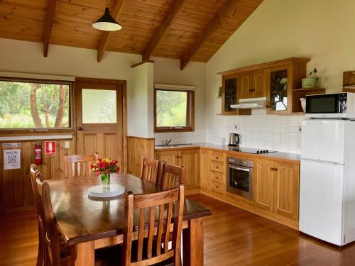 坎贝尔港戴茜山乡村山林小屋的厨房配有桌子和白色冰箱。