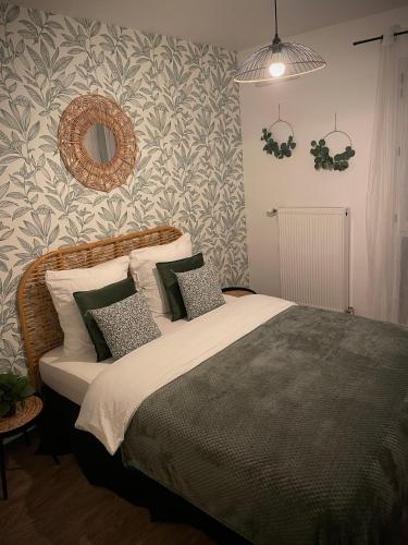 奥尔良Nature&Spa Appartement avec Jacuzzi & Sauna privé的一间卧室配有带枕头和镜子的床
