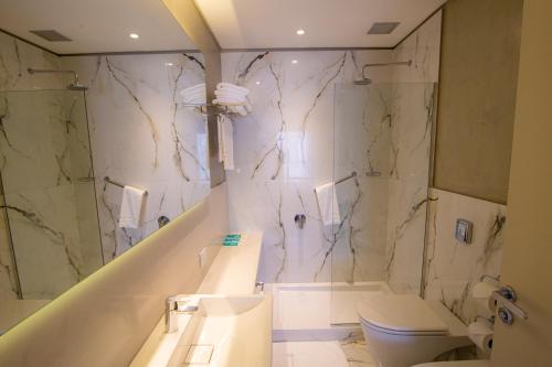 马德普拉塔Hotel Treinta-Seis的一间带水槽、淋浴和卫生间的浴室