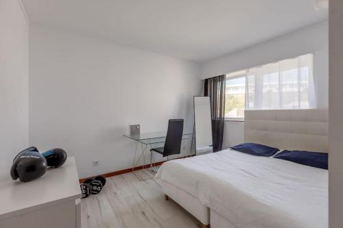 里斯本Spacious 3-bedroom condo in Lisbon的一间卧室配有一张床和一张带电脑的书桌