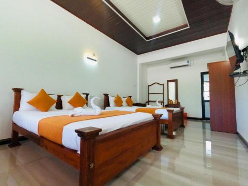 马特莱Ama Residence的一间卧室配有两张带橙色和白色床单的床
