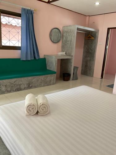 涛岛岛上温泉度假村的一间卧室配有一张床,上面有两条毛巾