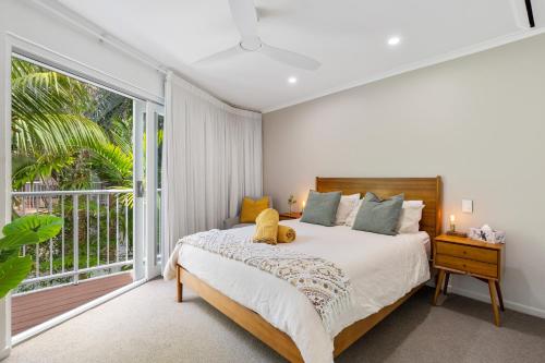 努萨角Little cove gem - walking distance to the most famous Noosa beach!的一间卧室设有一张床和一个大窗户