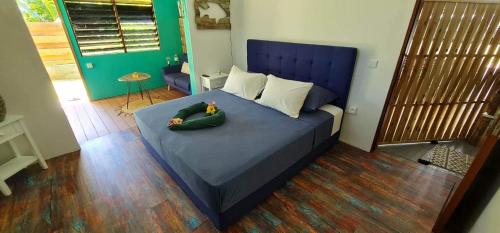MahinaPointe Venus Lodge的一间卧室配有一张蓝色的床,里面放着两只填充的动物