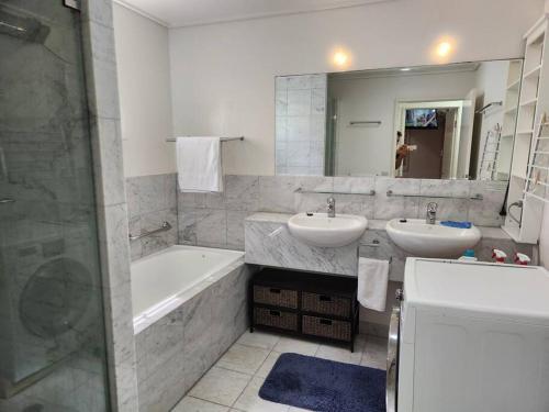 South StradbrokeWater View. 1bedroom Sleeps 2. WI-FI, Wash Machine的浴室配有2个盥洗盆、浴缸和淋浴。