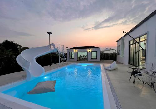 清莱373 pool villa的一座房子里一个带滑梯的游泳池