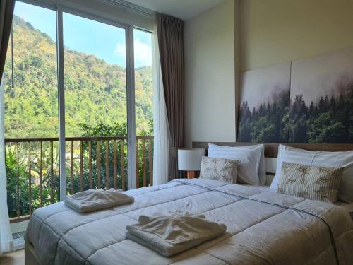 Ban Tha MaprangBaan Khaoyai cozy的一间卧室设有一张大床和大窗户