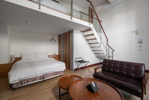安平区安平肯辛顿旅店的一间卧室配有床、沙发和楼梯。