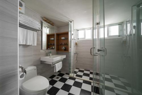安平区安平肯辛顿旅店的浴室配有卫生间、盥洗盆和淋浴。