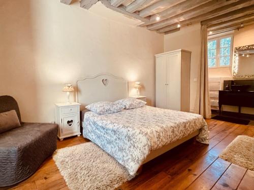 布雷西尔Domaine de la Villa du Moulin de Champie - Plaine de Versailles的一间卧室配有一张床、一把椅子和一张沙发