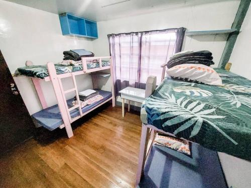 碧瑶Convenient 3-Bedroom Apartment的一间卧室设有两张双层床,铺有木地板。