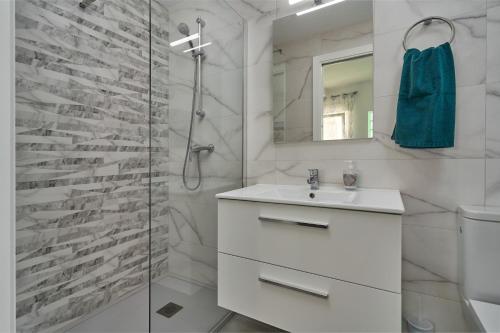 内尔哈Verano Azul的白色的浴室设有水槽和淋浴。