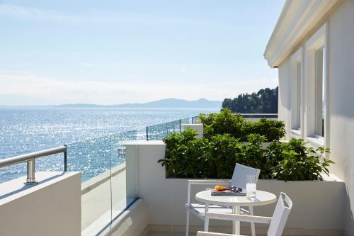 科孚镇Mon Repos Palace - Adults Only的阳台配有桌子,享有海景。