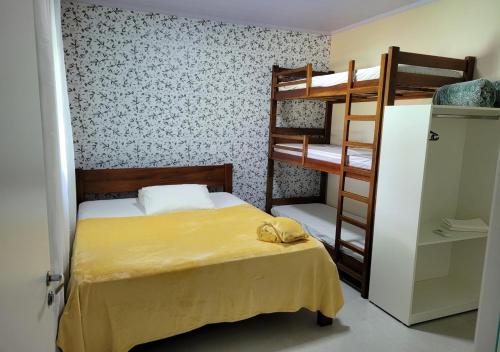 戈亚斯州上帕莱索Kit Dona Branca的一间卧室配有两张双层床和一张黄色的床罩