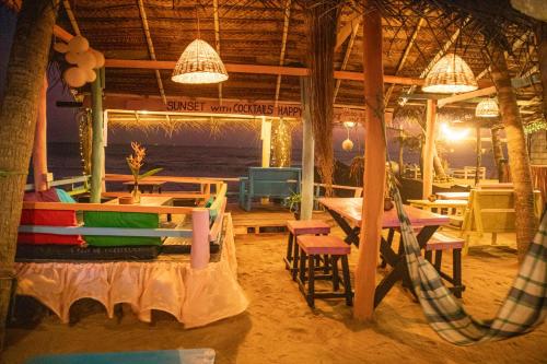 高尔Oynise Beach Cabin的海滩上的餐厅,配有桌椅