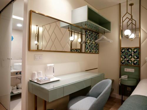 里斯本New Style Lisbon Hotel的客房设有带椅子和镜子的梳妆台