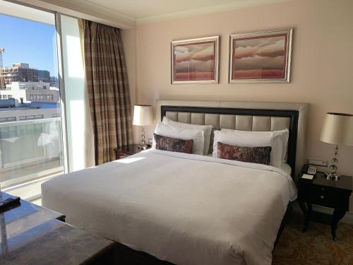 开普敦Private Luxury Residence 906 at TAJ Cape Town的一间卧室设有一张大床和一个大窗户