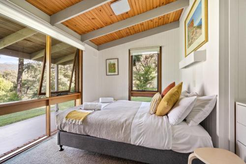 芒特比尤蒂吉瓦山林小屋的一间卧室设有一张床和一个大窗户