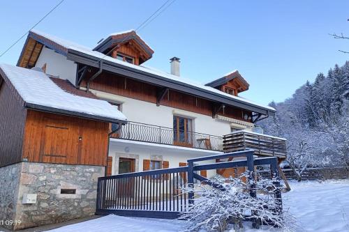 Viuz-en-SallazGîte Cœur de Haute-Savoie的前面的地面上积雪的房子