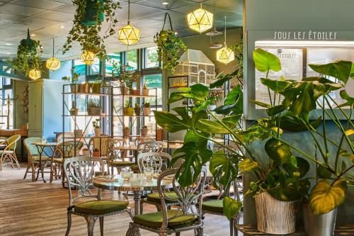 巴黎巴黎巴士底歌剧院宜必思酒店的一间设有桌椅的餐厅,种植了植物