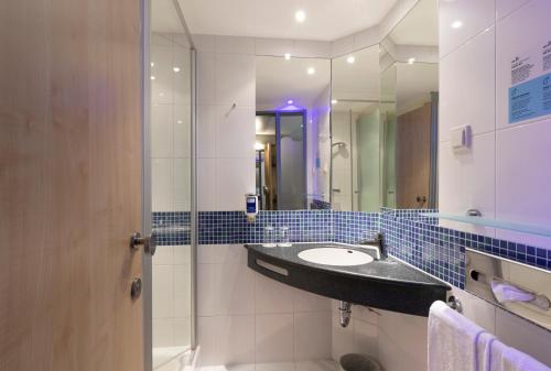 施瓦巴赫Holiday Inn Express Nürnberg-Schwabach的一间带水槽和镜子的浴室