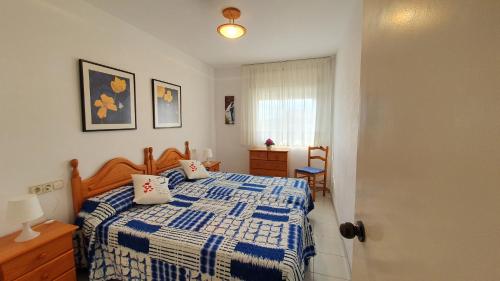 埃斯塔蒂特Blau Mar B 38的卧室配有蓝色和白色的床和窗户。