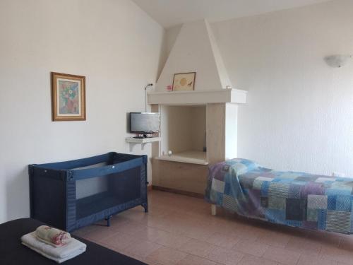 切萨雷奥港Cosy Residenze的一间卧室配有一张床,并在一间客房内配有电视。
