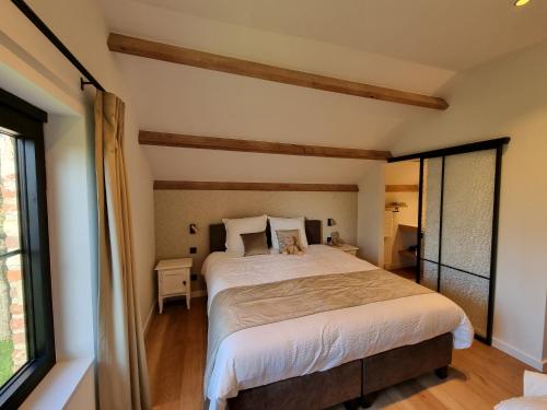 Lo-ReningeDe Bogaerd的一间卧室设有一张大床和一个窗户。