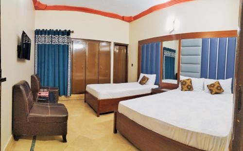 卡拉奇Subhan Palace Guest House的酒店客房,配有两张床和椅子