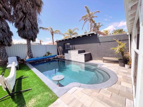 杰拉尔顿Luxe Family Retreat! Pool, Sauna, Playground, Netflix, Disney Plus的一座房子后院的游泳池