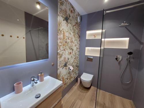 卡尔帕奇Apartament Pod Papugami 2 Karpatia Resort的浴室配有卫生间、盥洗盆和淋浴。