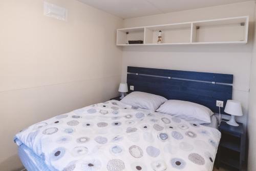 摩拉瓦托普利采Holiday cottage II with 2 Thermal Riviera Tickets的一间卧室配有一张大床和蓝色床头板