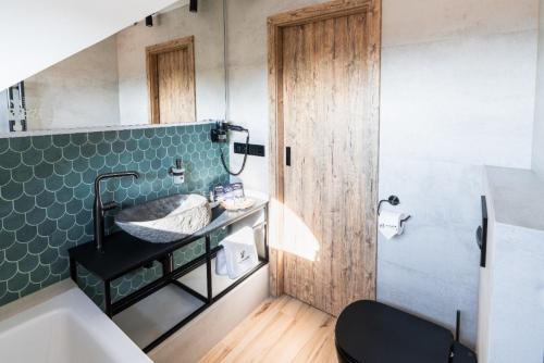 米库洛夫Penzion Monner的一间带水槽和绿色瓷砖墙的浴室