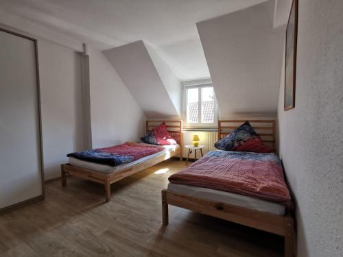 哈特斯海姆Pension zum Hirsch的阁楼上的卧室配有两张床